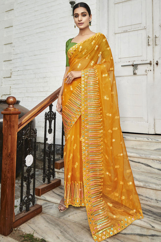 Embroidered And Stone Work Party Style Luxurious Organza Saree In Mustard Color