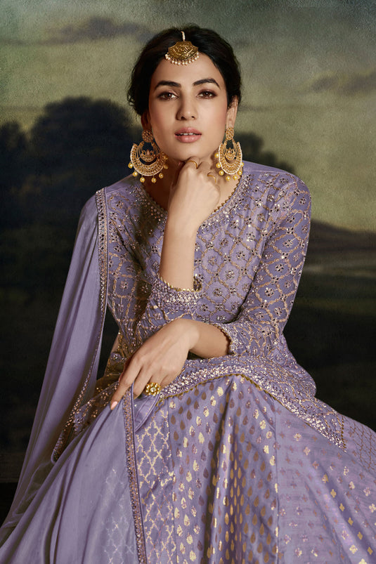 Sonal Chauhan Appealing Embroidered Work On Net Fabric Sharara Top Lehenga In Lavender Color